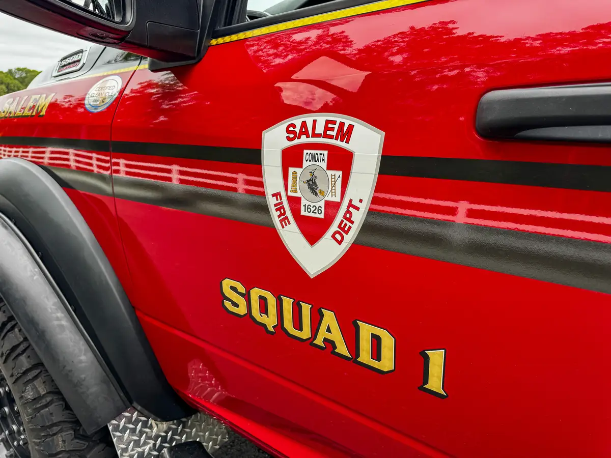 Front fender and side-door striping close-up with hood badge visible.